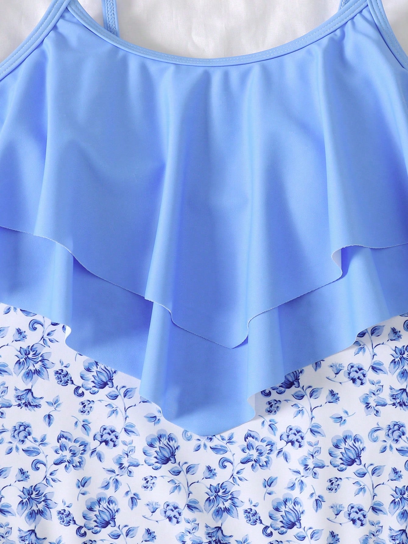 NEWSHEIN tween girls fitted one-piece swimsuit in blue and white plant pattern with ruffle tiered detail, spaghetti straps, and lined body for beach or resort wear