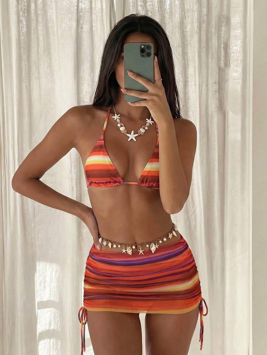 Women's black 3-piece bikini set featuring a halter triangle top with removable padding, high-waisted bottoms, and a knee-length mesh skirt with tie details.