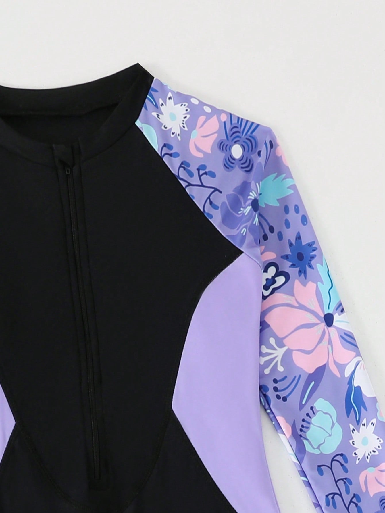 Tween girls black one-piece swimsuit with long sleeves, high neck, zipper detail, graphic leopard heart print, and fitted full-coverage swimwear style.