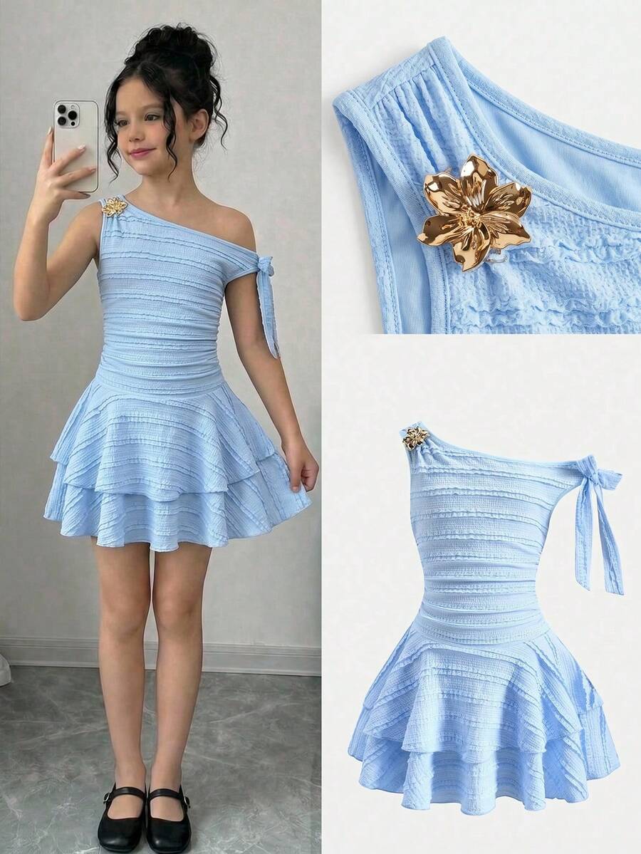 Tween girl wearing an apricot asymmetric skater dress with ruffle and applique details for party and formal occasions.