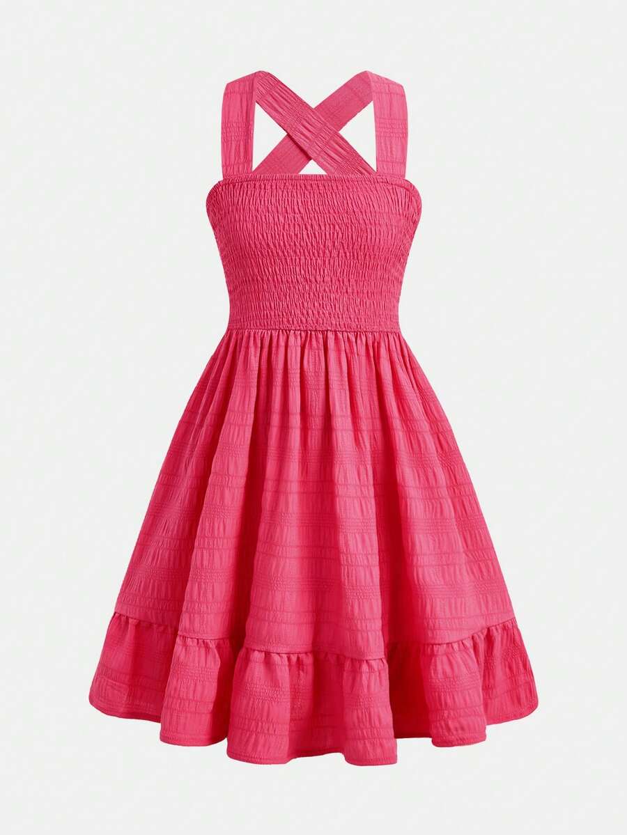 Pink sleeveless tween girls vacation dress with all-over fruit and vegetable print, strap neckline, belted high waist, cut-out detail, and flared ruffle hem.