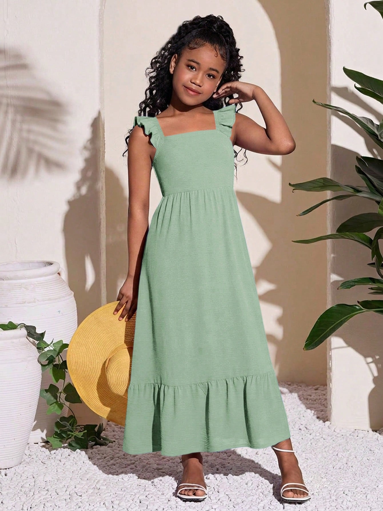 Tween girls A-line vacation dress with square neck, shirred cinched waist, ruffle details, zipper closure, and flounce hem.