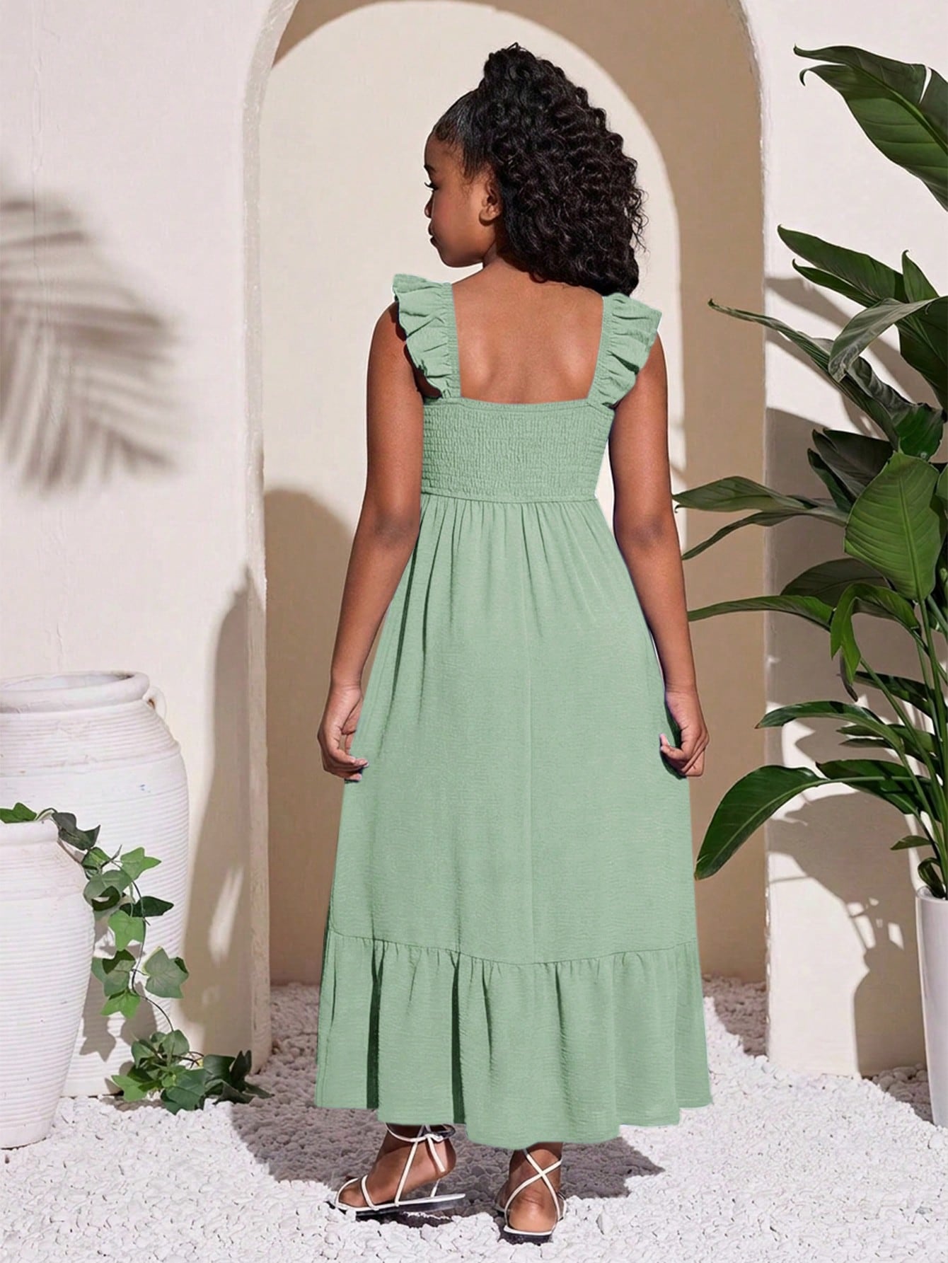 Tween girls A-line vacation dress with square neck, shirred cinched waist, ruffle details, zipper closure, and flounce hem.