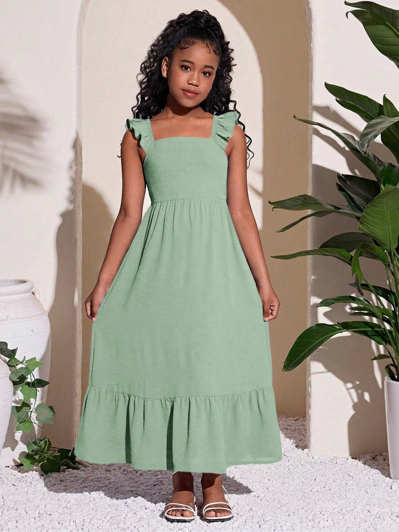 Tween girls A-line vacation dress with square neck, shirred cinched waist, ruffle details, zipper closure, and flounce hem.