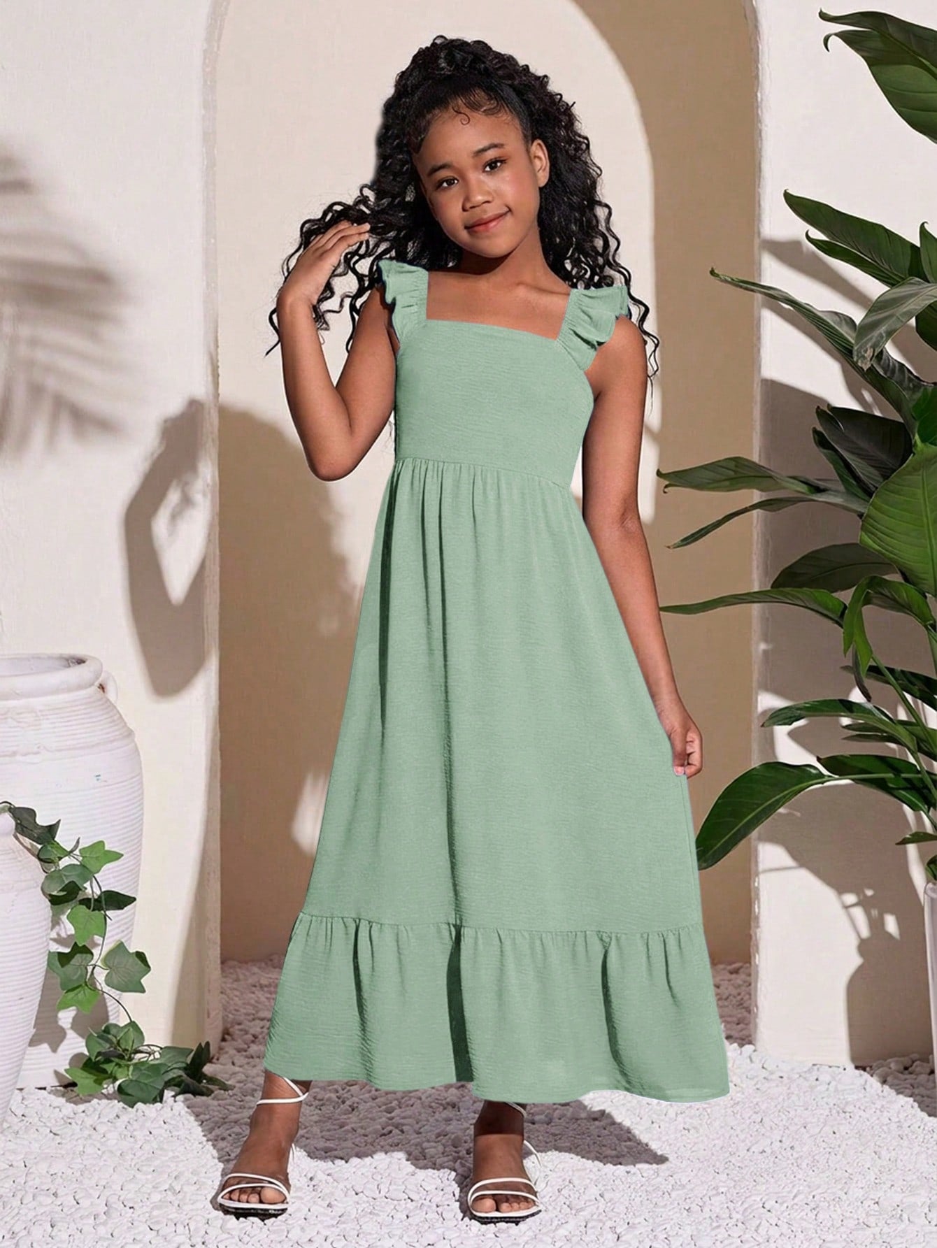Tween girls A-line vacation dress with square neck, shirred cinched waist, ruffle details, zipper closure, and flounce hem.