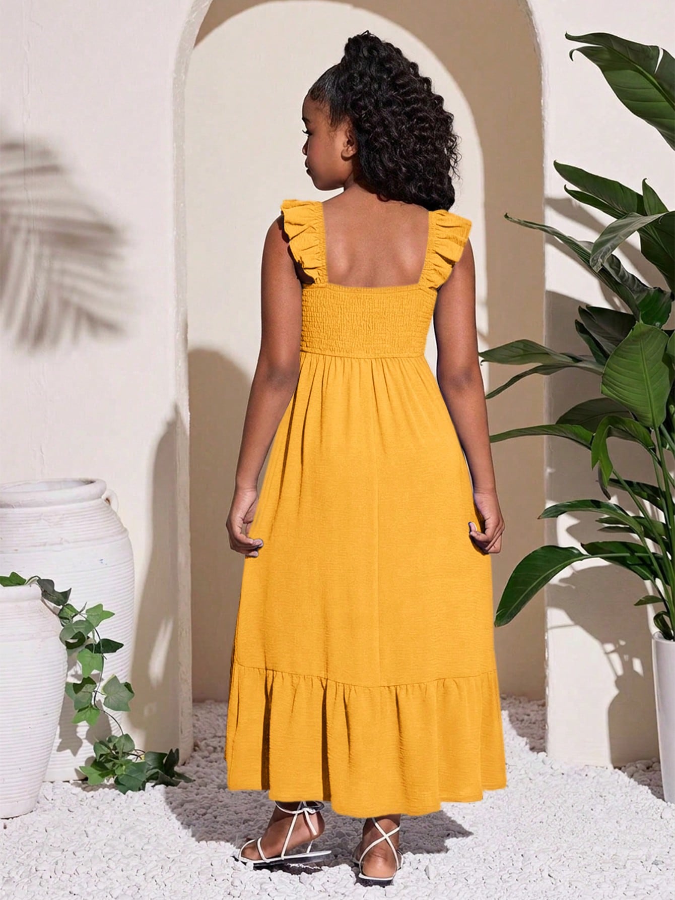 Tween girls A-line vacation dress with square neck, shirred cinched waist, ruffle details, zipper closure, and flounce hem.