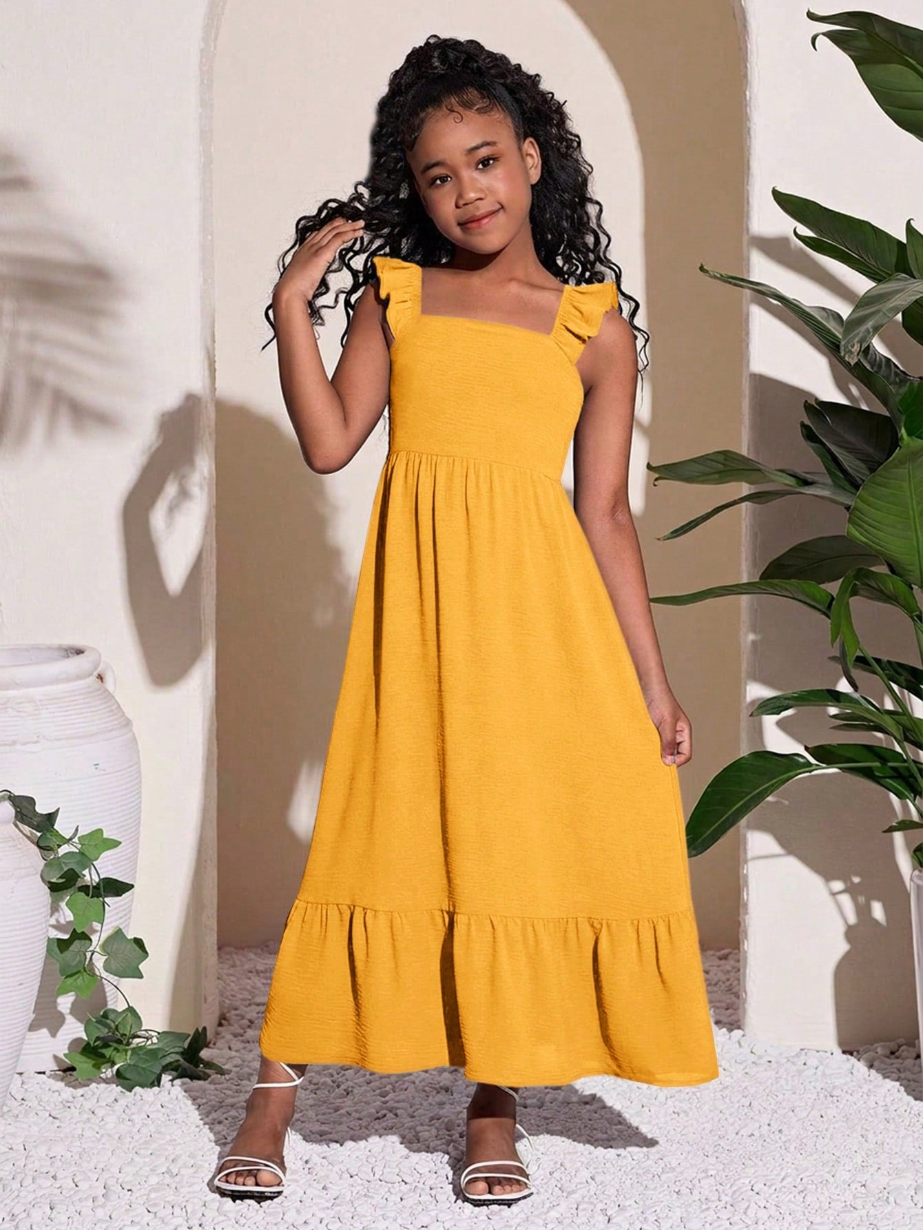 Tween girls A-line vacation dress with square neck, shirred cinched waist, ruffle details, zipper closure, and flounce hem.