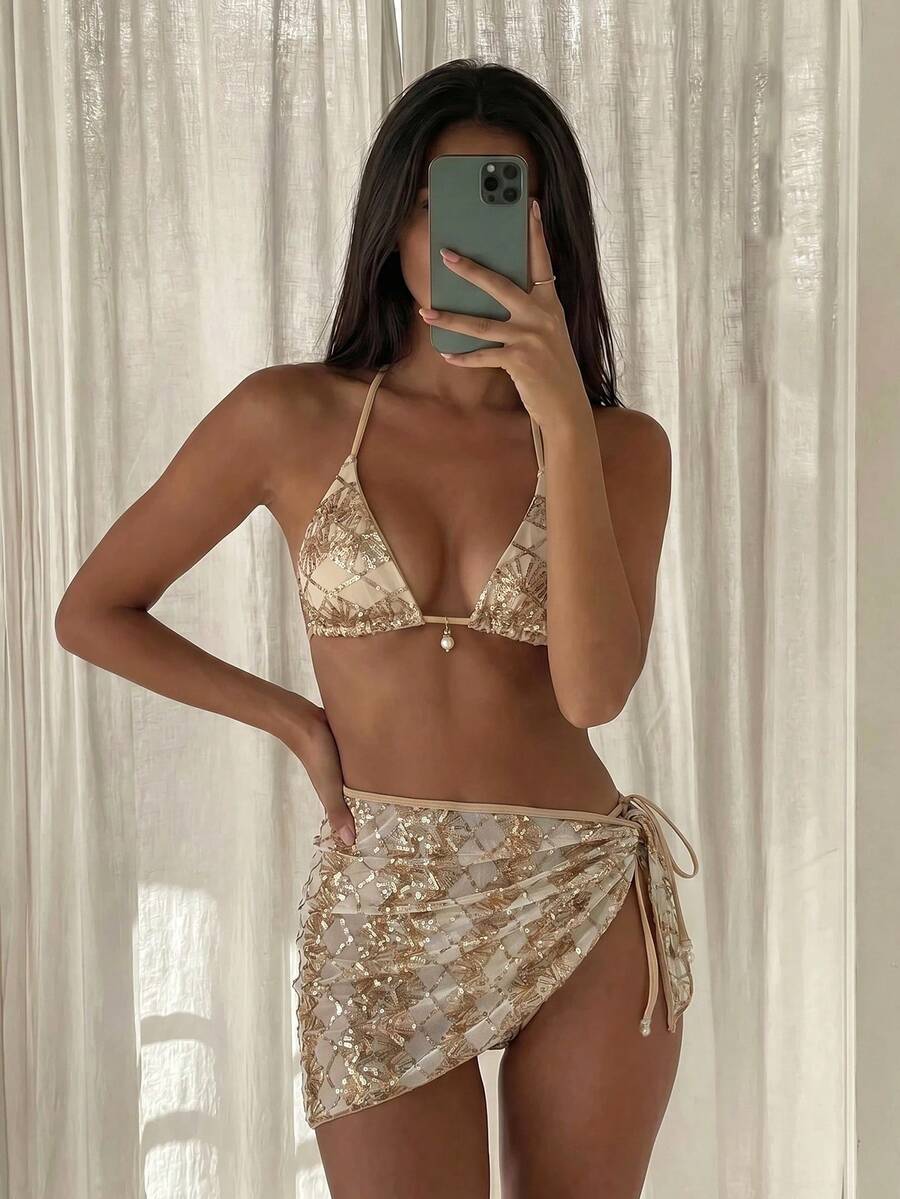 Women's 3-piece blue tropical shell print bikini set featuring a halter bralette top, low-waist tie-side bottom, and a matching sheer mesh cover-up skirt.