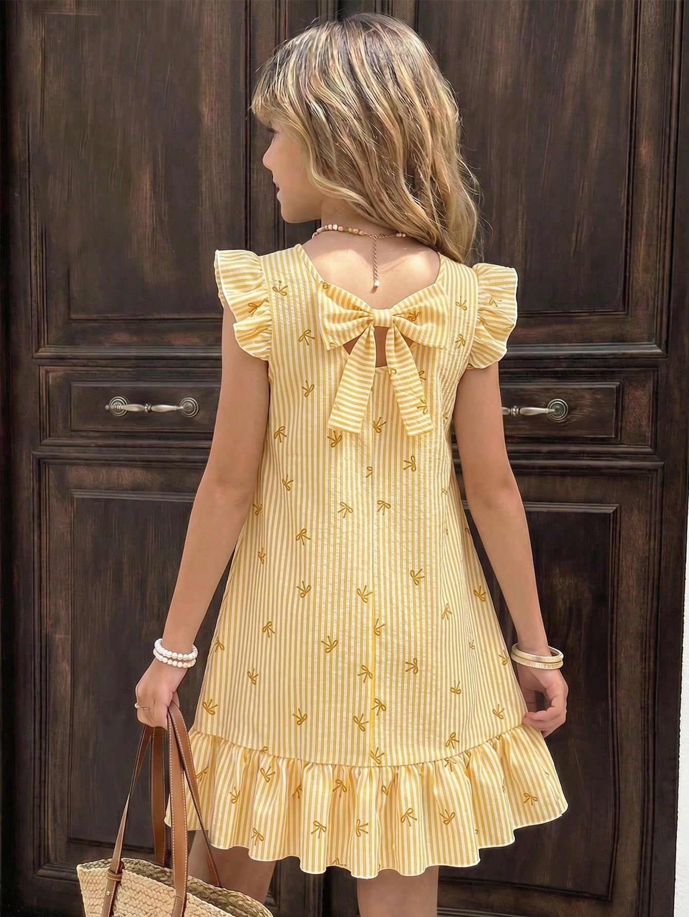 Tween girls apricot vacation midi dress featuring a round neck, cut out details, ruffle flounce accents, and geometric pattern.