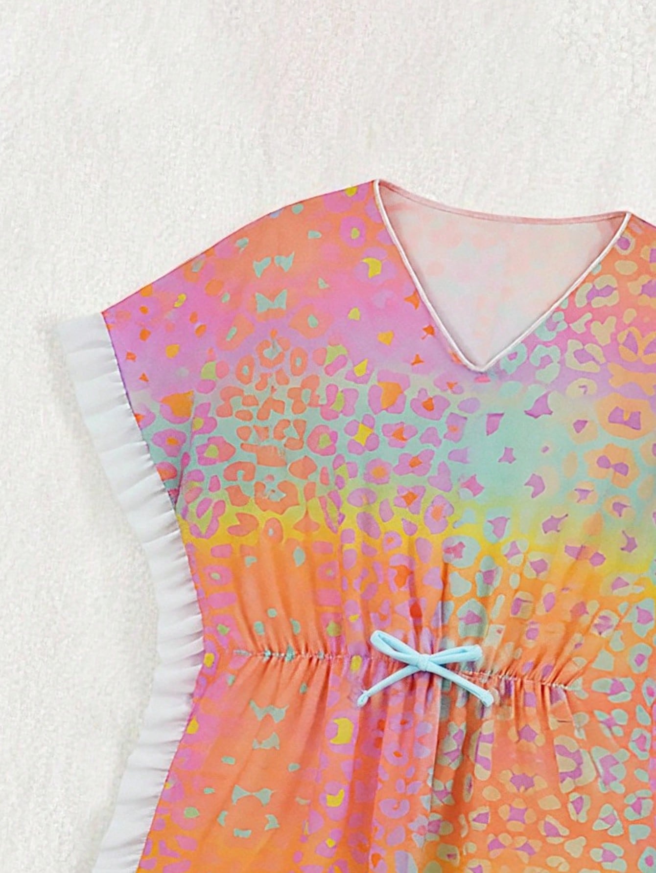 Blue tween girls swimsuit cover up with geometric starfish print, ruffle trim, round neck, short sleeves, and semi-sheer knit fabric for beach or pool wear.