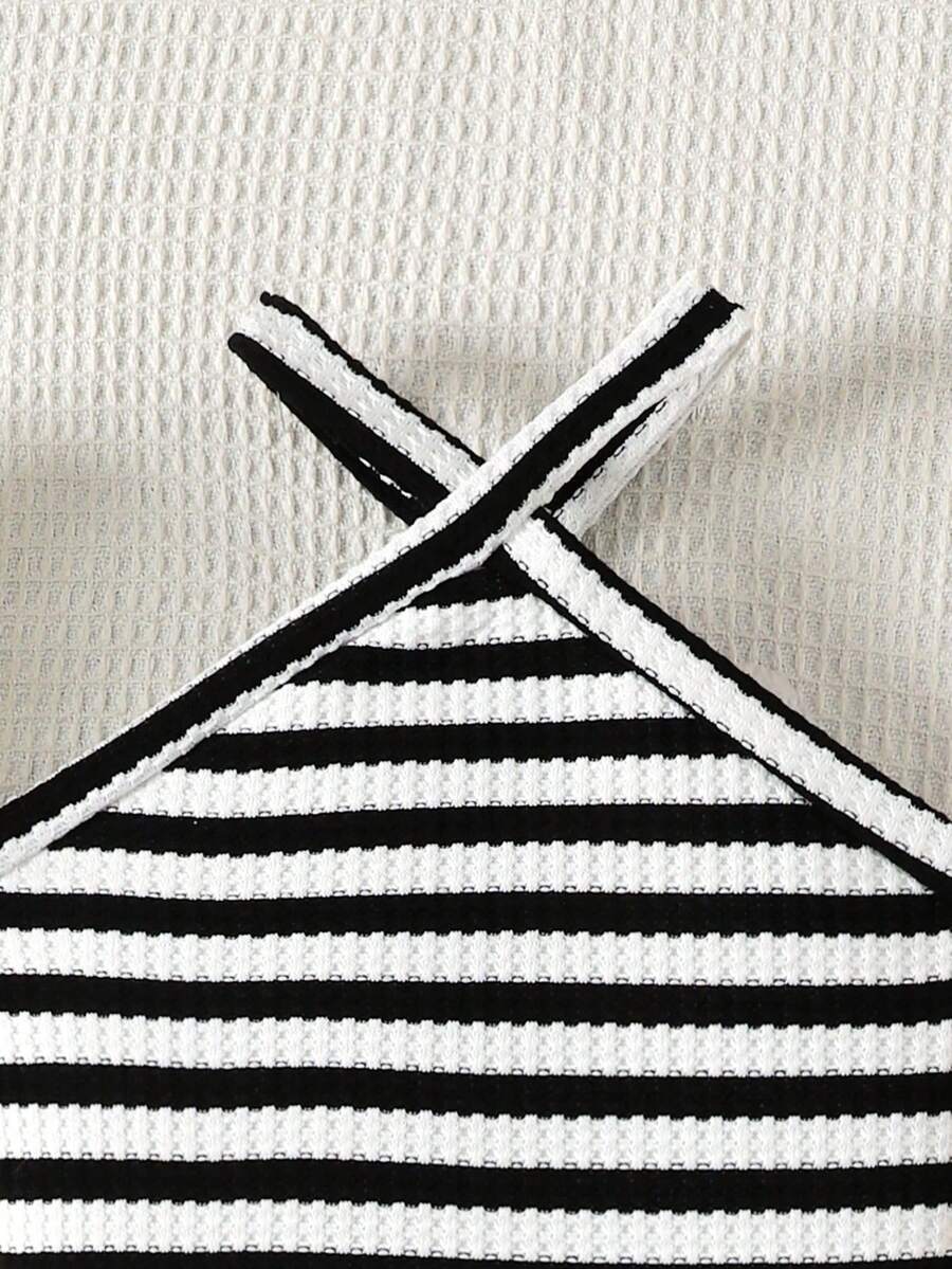 Black and white striped 2-piece set for tween girls featuring a halter sleeveless pullover top with criss-cross knot detail and matching paperbag waist shorts.