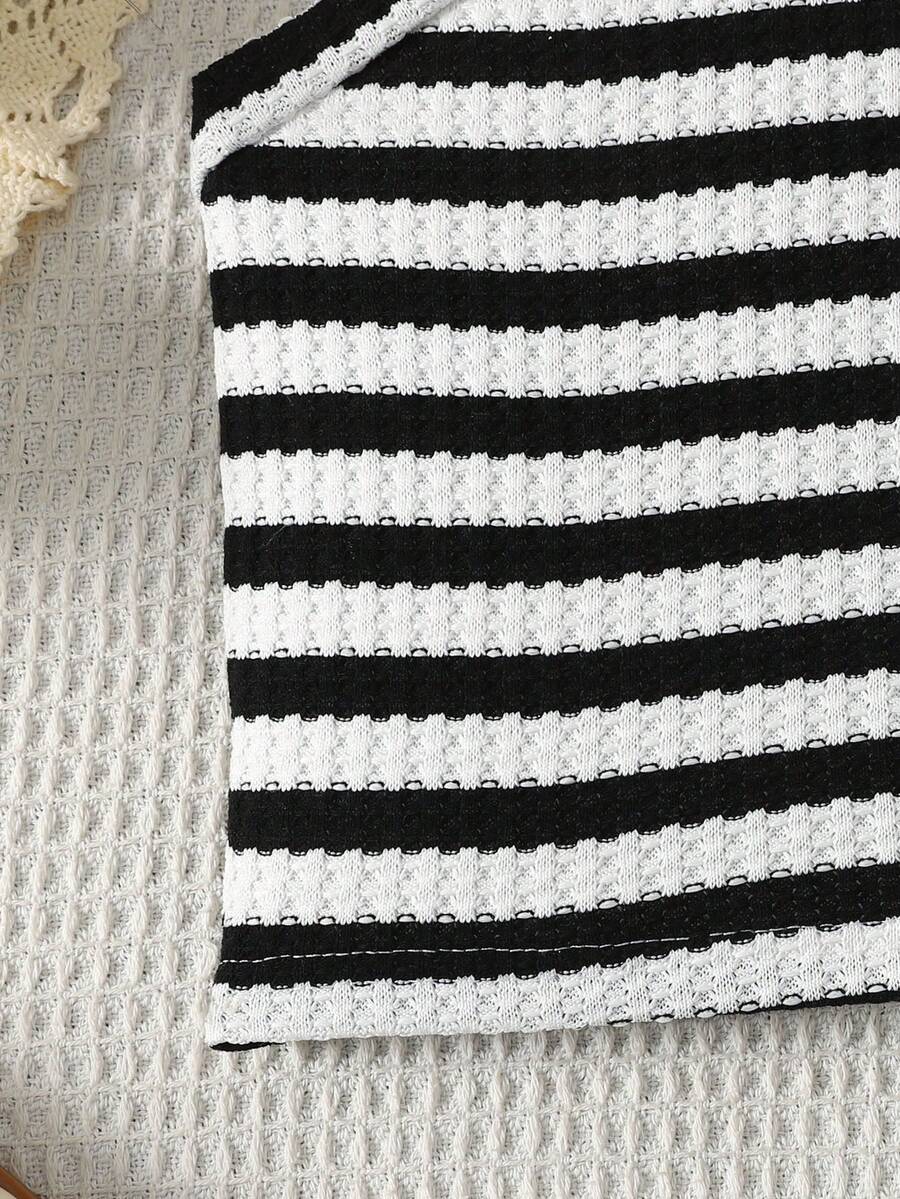 Black and white striped 2-piece set for tween girls featuring a halter sleeveless pullover top with criss-cross knot detail and matching paperbag waist shorts.