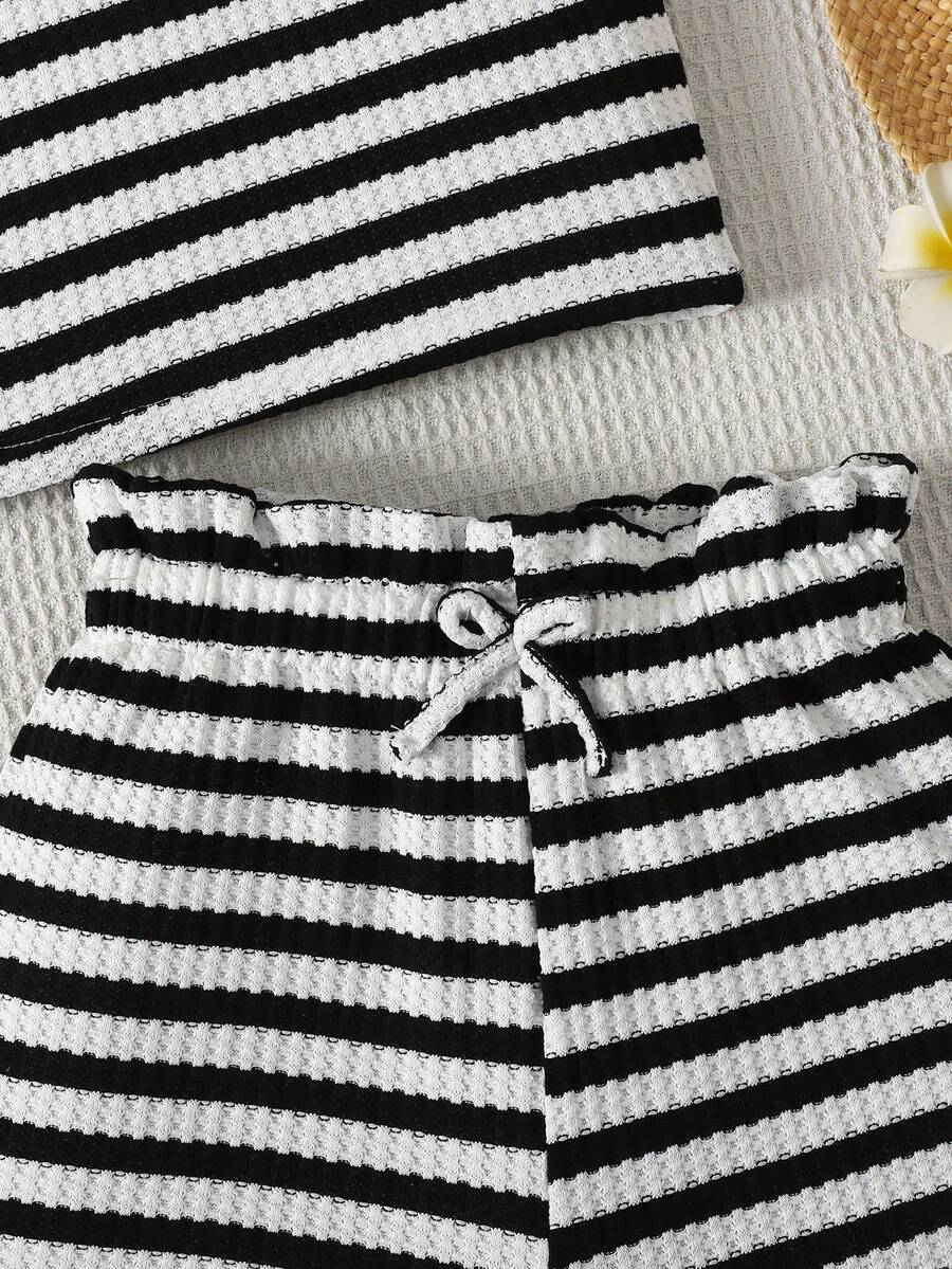 Black and white striped 2-piece set for tween girls featuring a halter sleeveless pullover top with criss-cross knot detail and matching paperbag waist shorts.