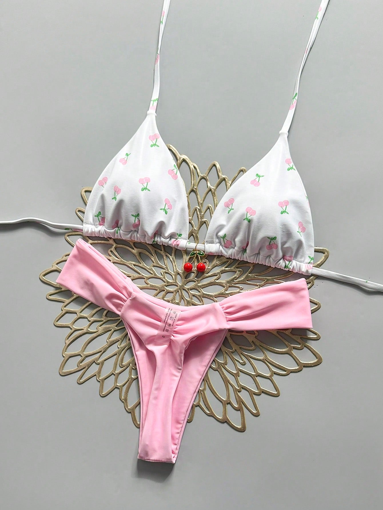 Women's 2-piece triangle cup bikini set in solid color featuring woven pearl shell decoration, halter neckline, and high-waist side-tie ruched bottoms.