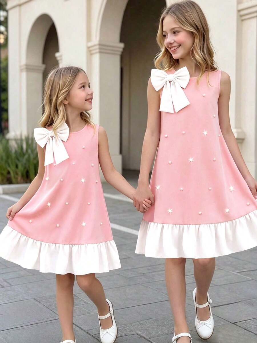 Yellow sleeveless colorblock dress for girls featuring a round neck, ruffle hem, and front bow detail.