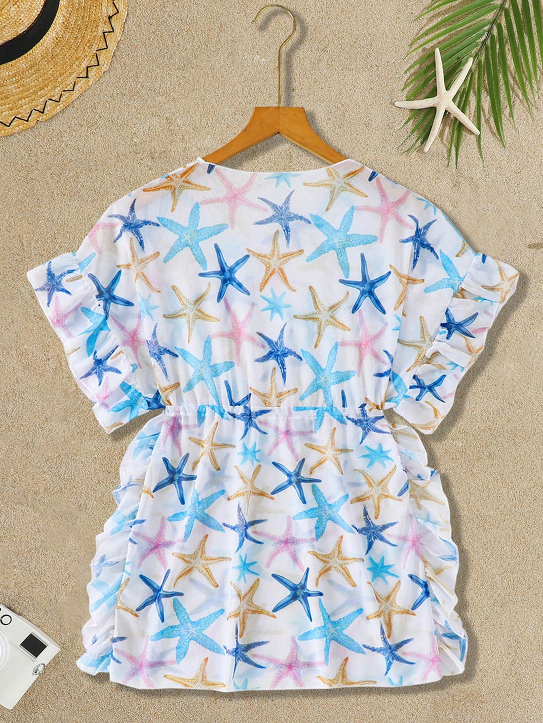 Blue tween girls swimsuit cover up with geometric starfish print, ruffle trim, round neck, short sleeves, and semi-sheer knit fabric for beach or pool wear.