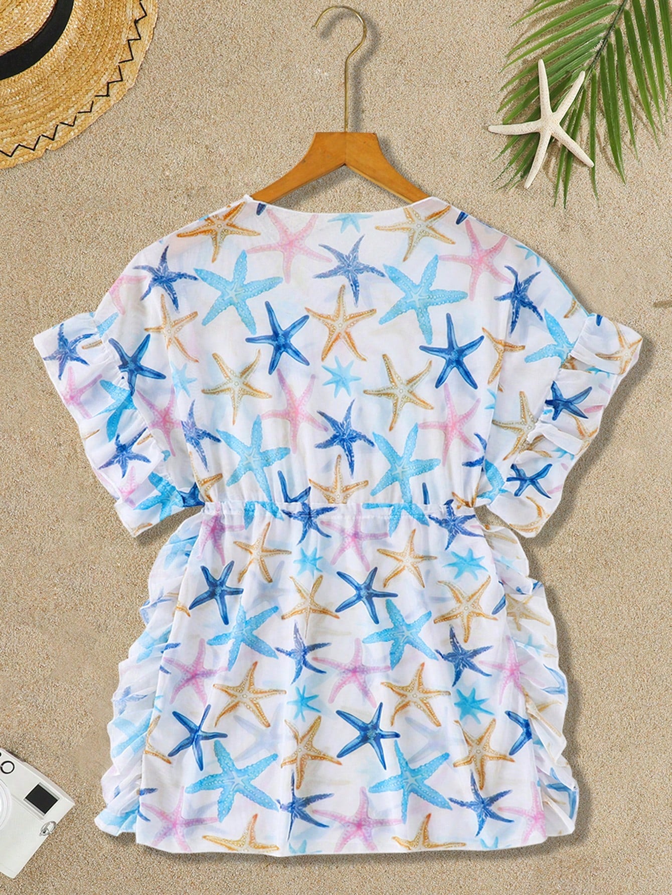 Blue tween girls swimsuit cover up with geometric starfish print, ruffle trim, round neck, short sleeves, and semi-sheer knit fabric for beach or pool wear.