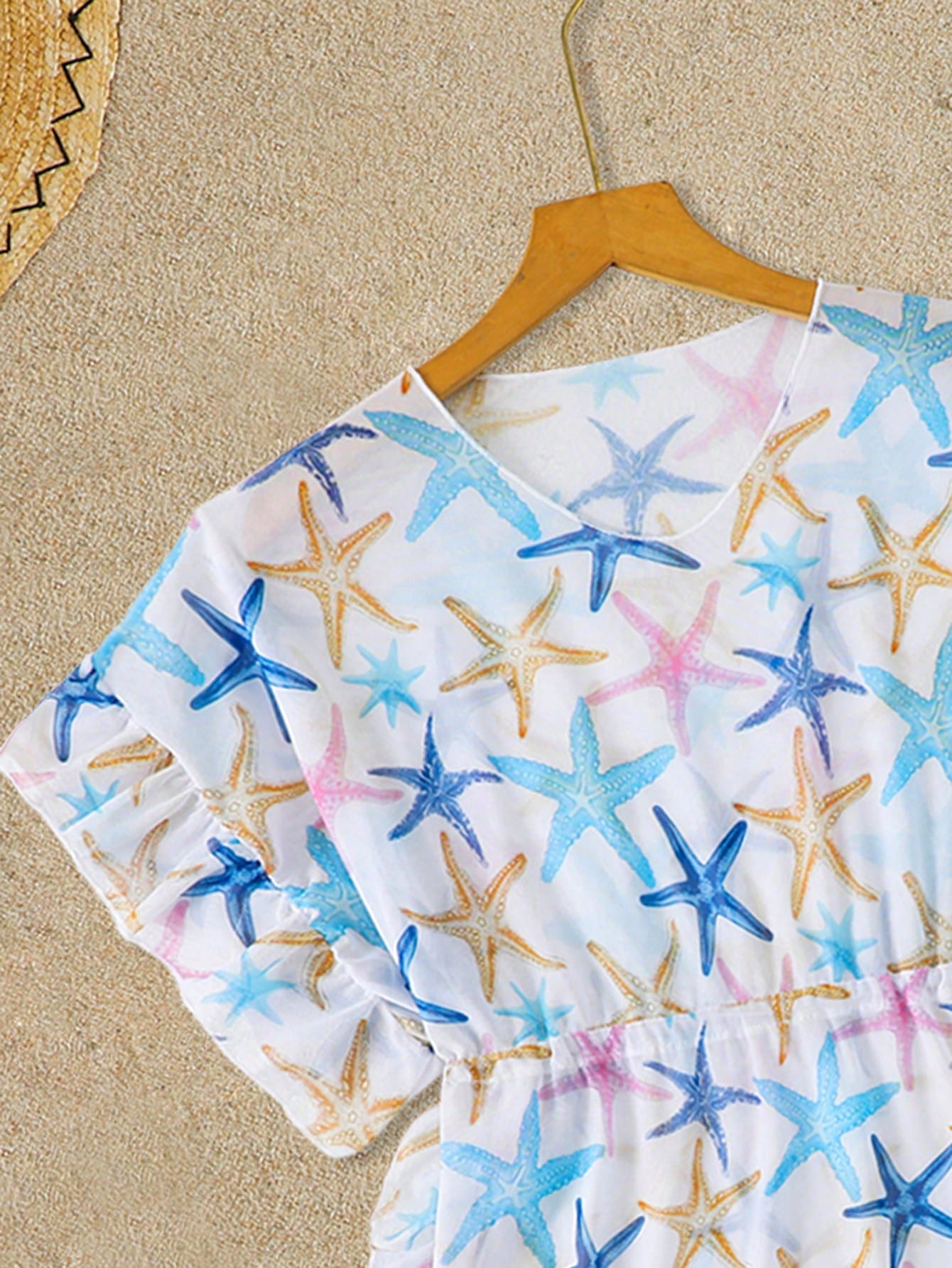 Blue tween girls swimsuit cover up with geometric starfish print, ruffle trim, round neck, short sleeves, and semi-sheer knit fabric for beach or pool wear.