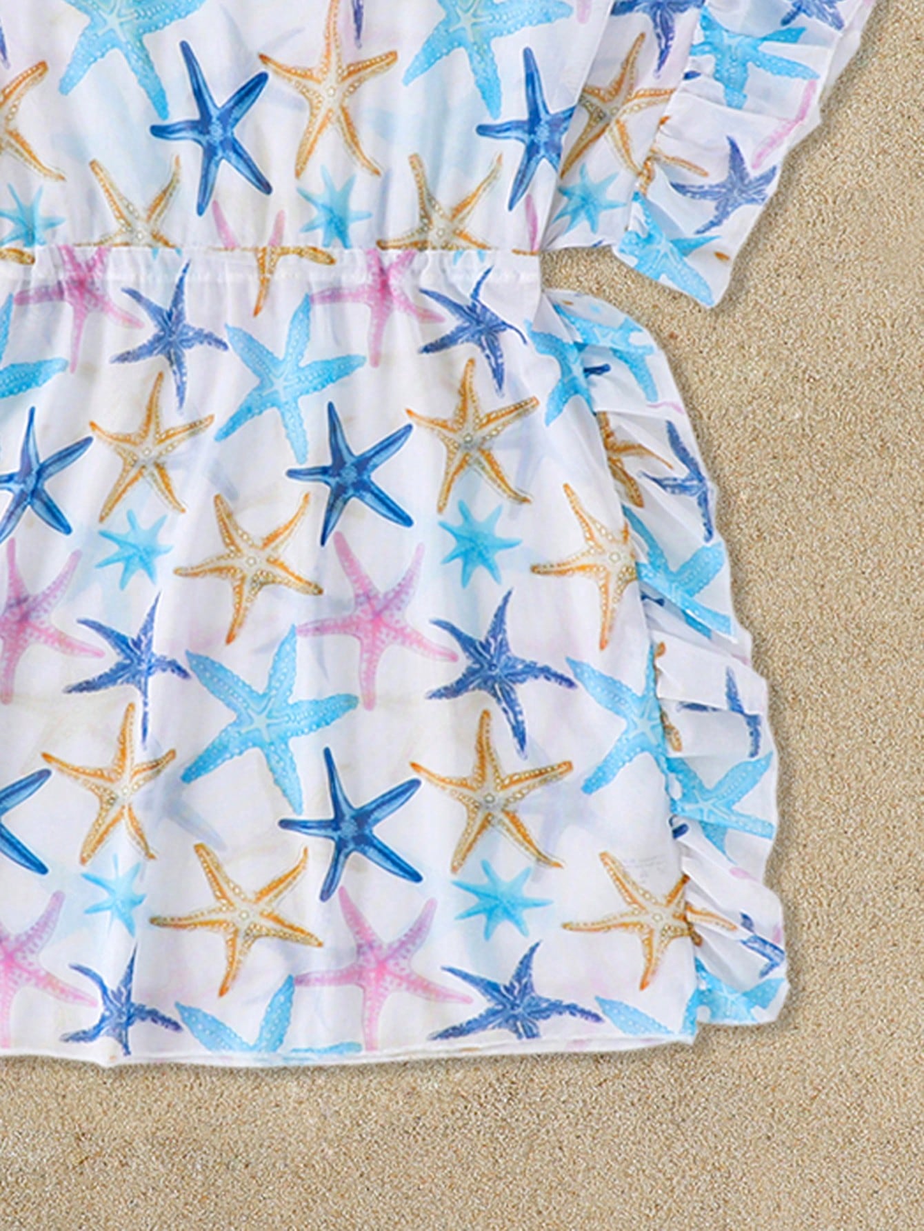 Blue tween girls swimsuit cover up with geometric starfish print, ruffle trim, round neck, short sleeves, and semi-sheer knit fabric for beach or pool wear.