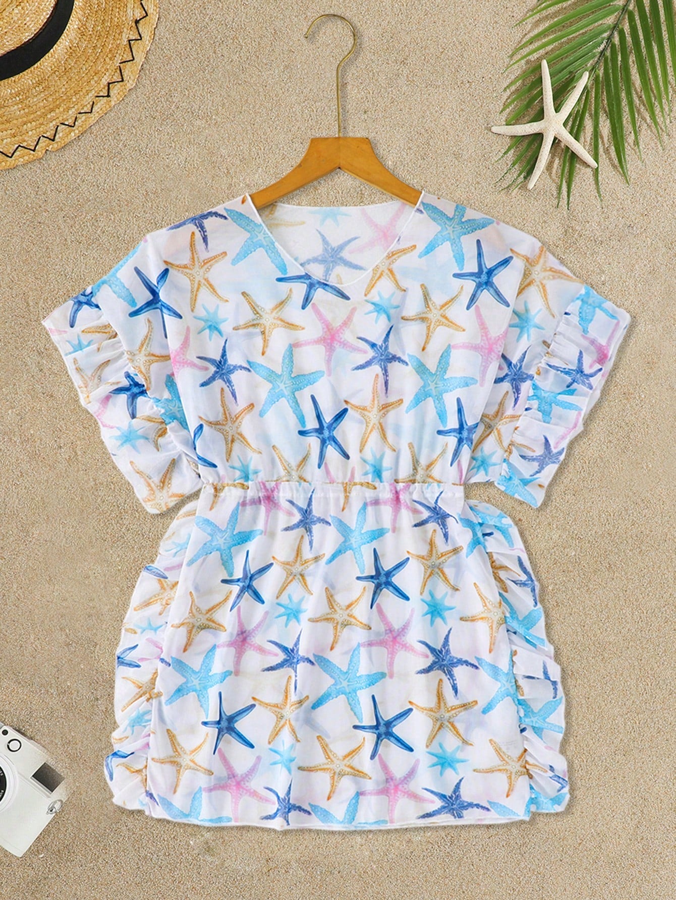 Blue tween girls swimsuit cover up with geometric starfish print, ruffle trim, round neck, short sleeves, and semi-sheer knit fabric for beach or pool wear.