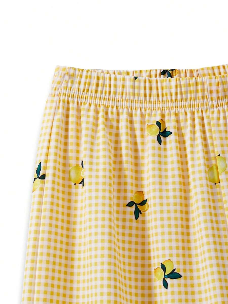 Tween girl wearing an apricot 2-piece outfit set featuring a shirred spaghetti strap short cami top and matching wide-leg long pants.