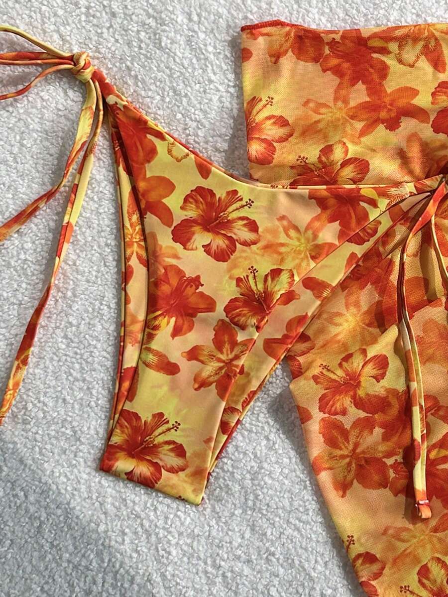 Women's 3-piece blue tropical shell print bikini set featuring a halter bralette top, low-waist tie-side bottom, and a matching sheer mesh cover-up skirt.