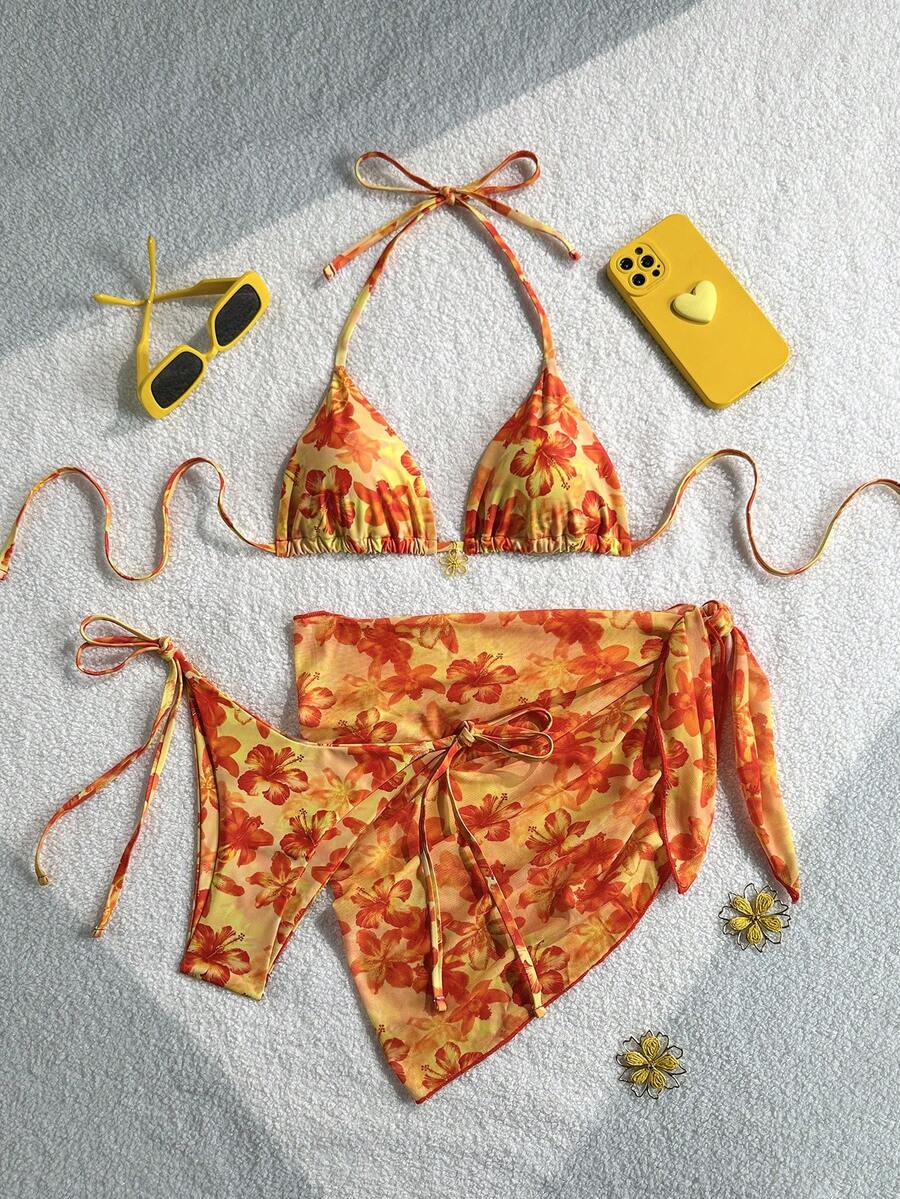 Women's 3-piece blue tropical shell print bikini set featuring a halter bralette top, low-waist tie-side bottom, and a matching sheer mesh cover-up skirt.