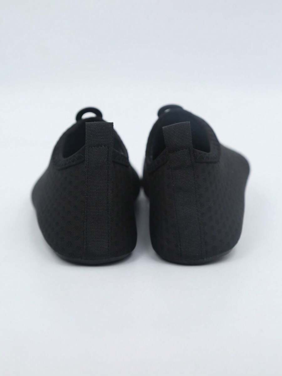 Kids black graphic water shoes with breathable Lycra upper, slip-on stretch design, and non-slip rubber outsole for boys and girls.