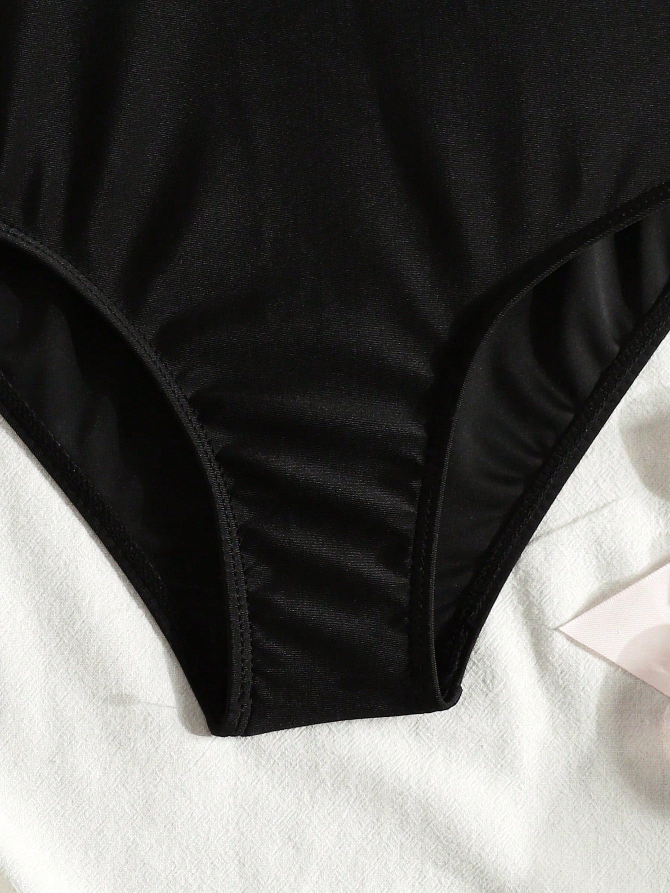 Tween girls' black and white one-piece swimsuit with striped patchwork design, scoop neck, asymmetrical cut-out detail, and fitted vacation swimwear style.