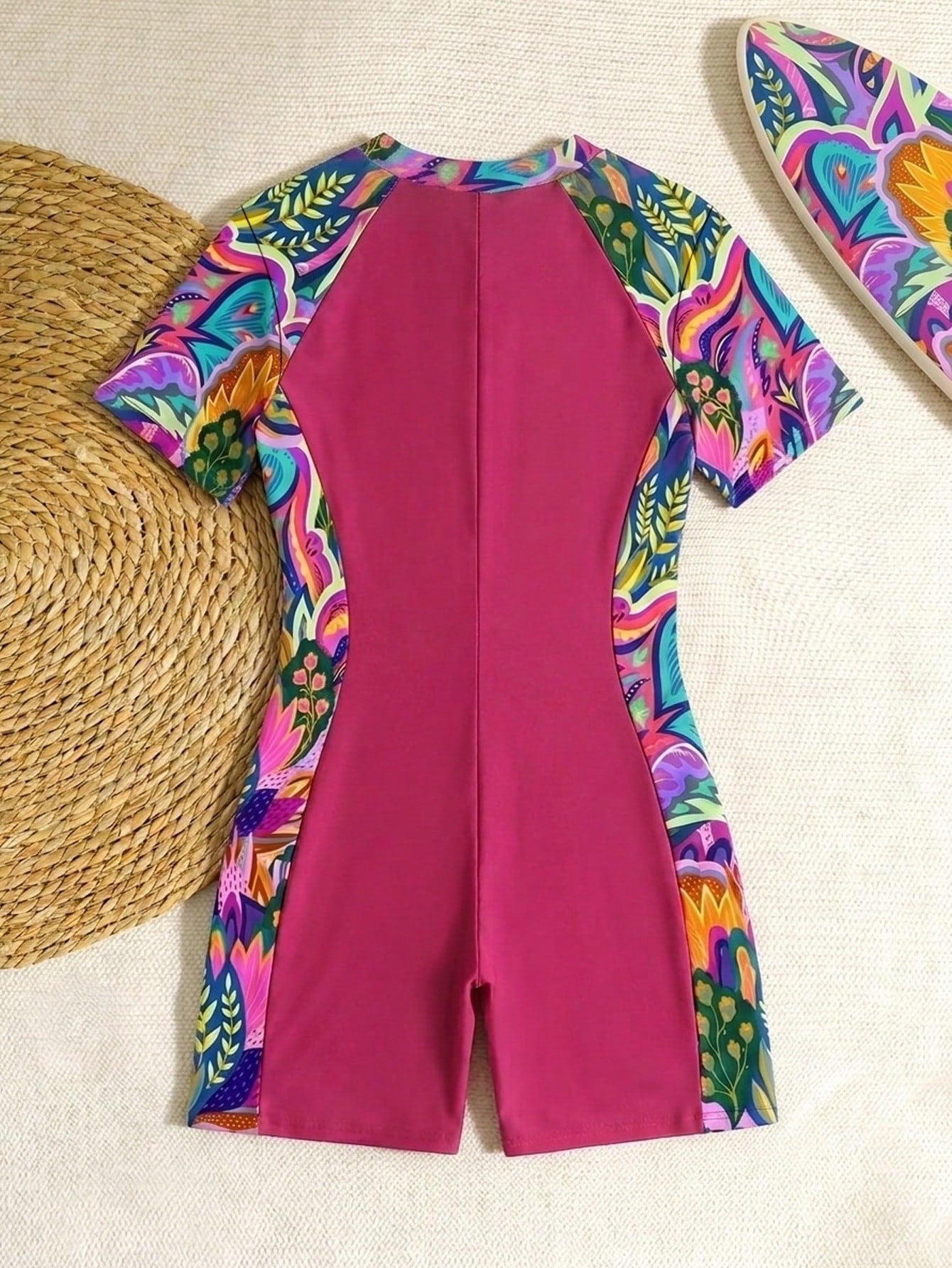 Black and white one-piece rashguard swimsuit for tween girls with short sleeves, high neck, zipper detail, fitted shape, and shorts-style bottom.