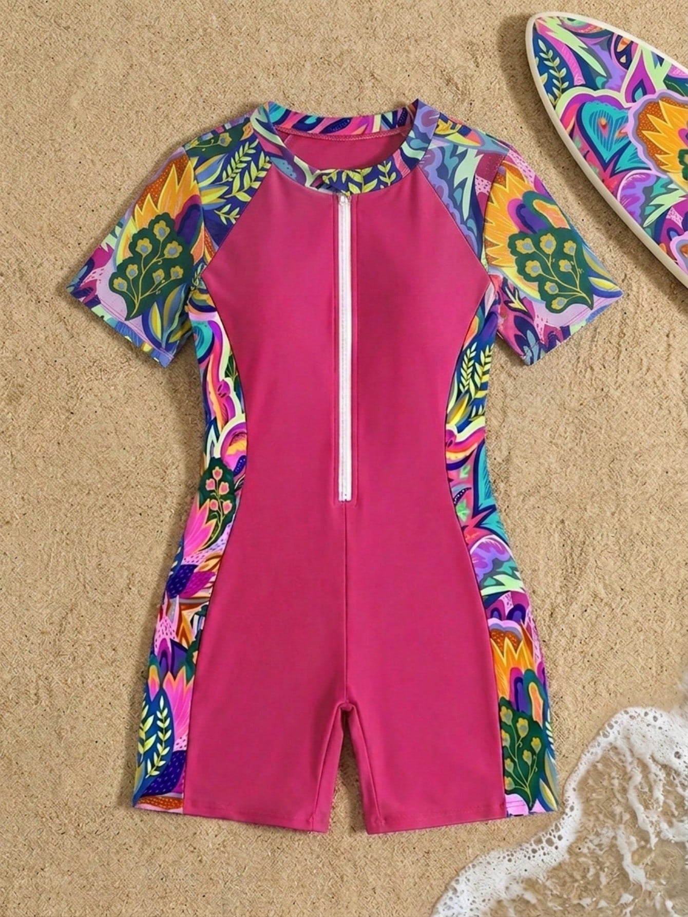 Black and white one-piece rashguard swimsuit for tween girls with short sleeves, high neck, zipper detail, fitted shape, and shorts-style bottom.