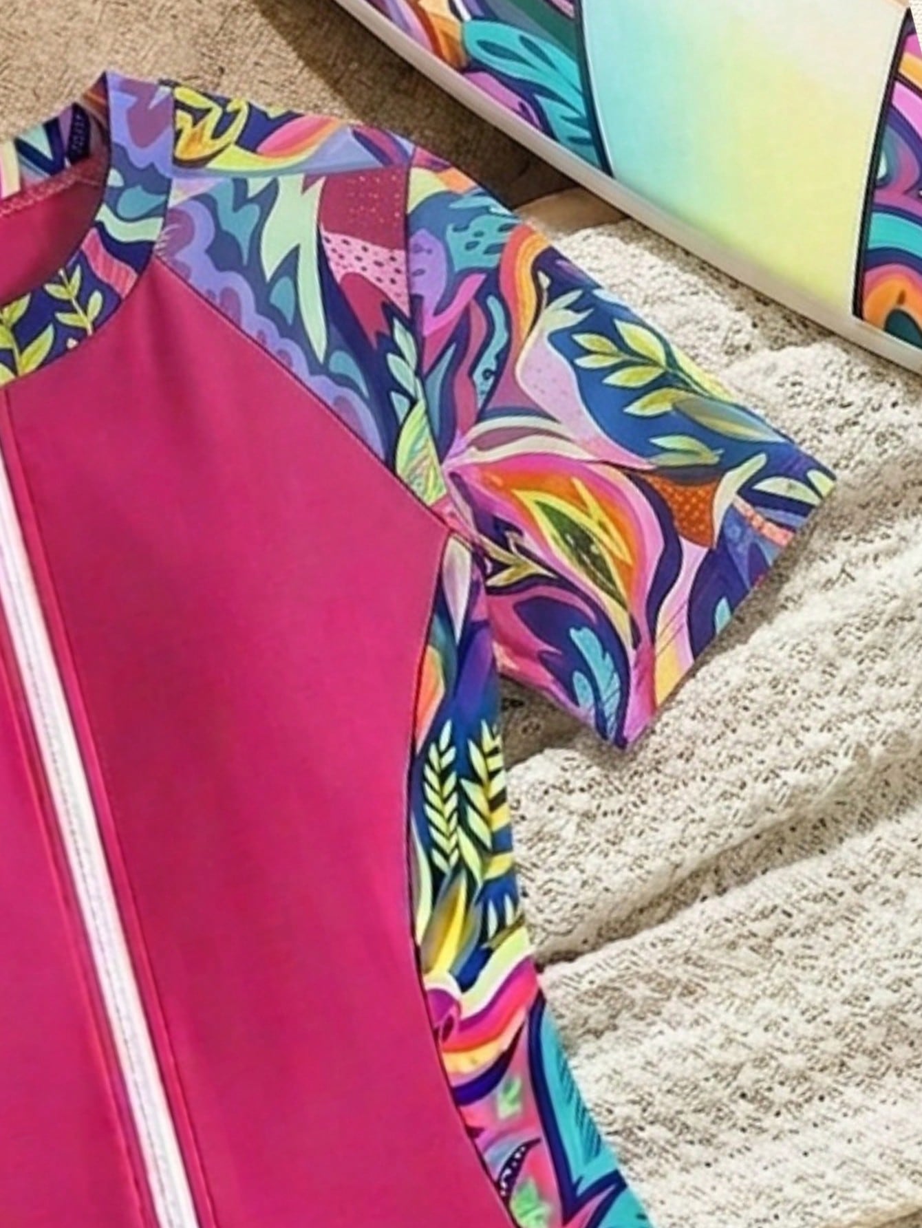 Black and white one-piece rashguard swimsuit for tween girls with short sleeves, high neck, zipper detail, fitted shape, and shorts-style bottom.