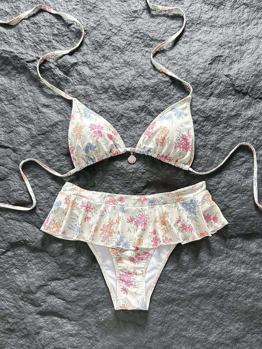 Women's 70s retro black and white polka dot bikini set featuring a halter triangle top and ultra low waist bottoms.