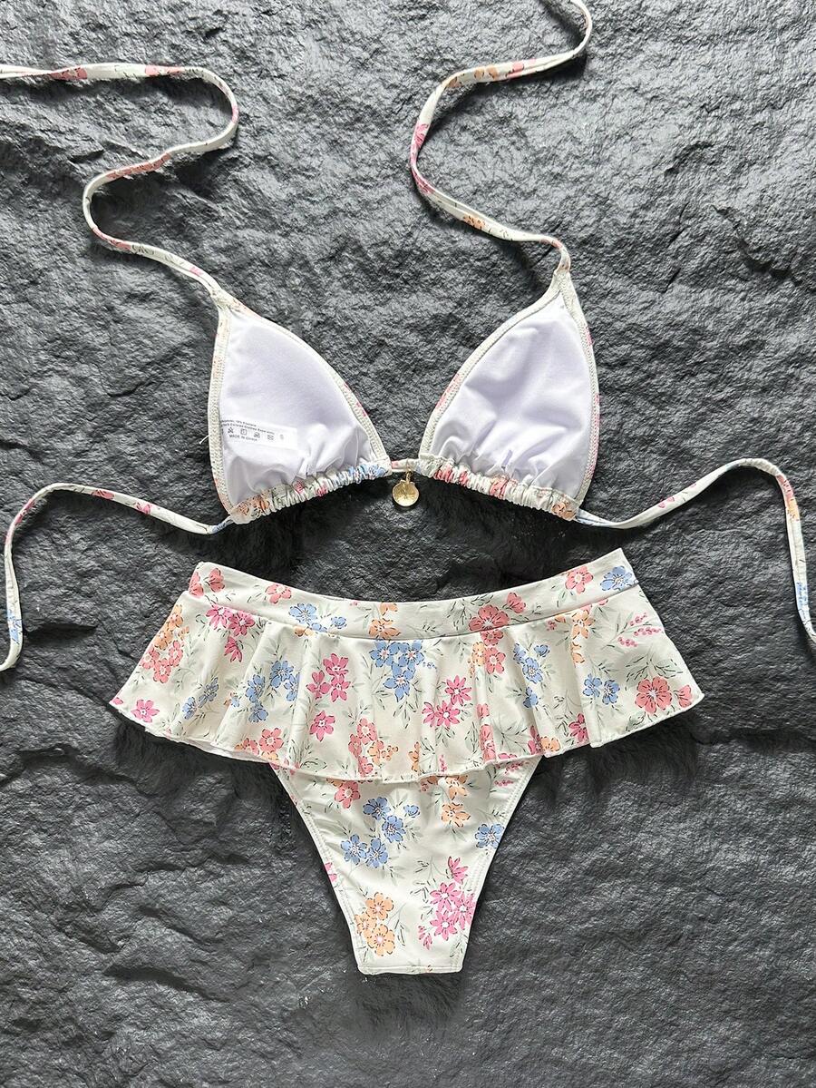 Women's 70s retro black and white polka dot bikini set featuring a halter triangle top and ultra low waist bottoms.