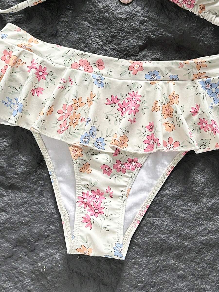 Women's 70s retro black and white polka dot bikini set featuring a halter triangle top and ultra low waist bottoms.