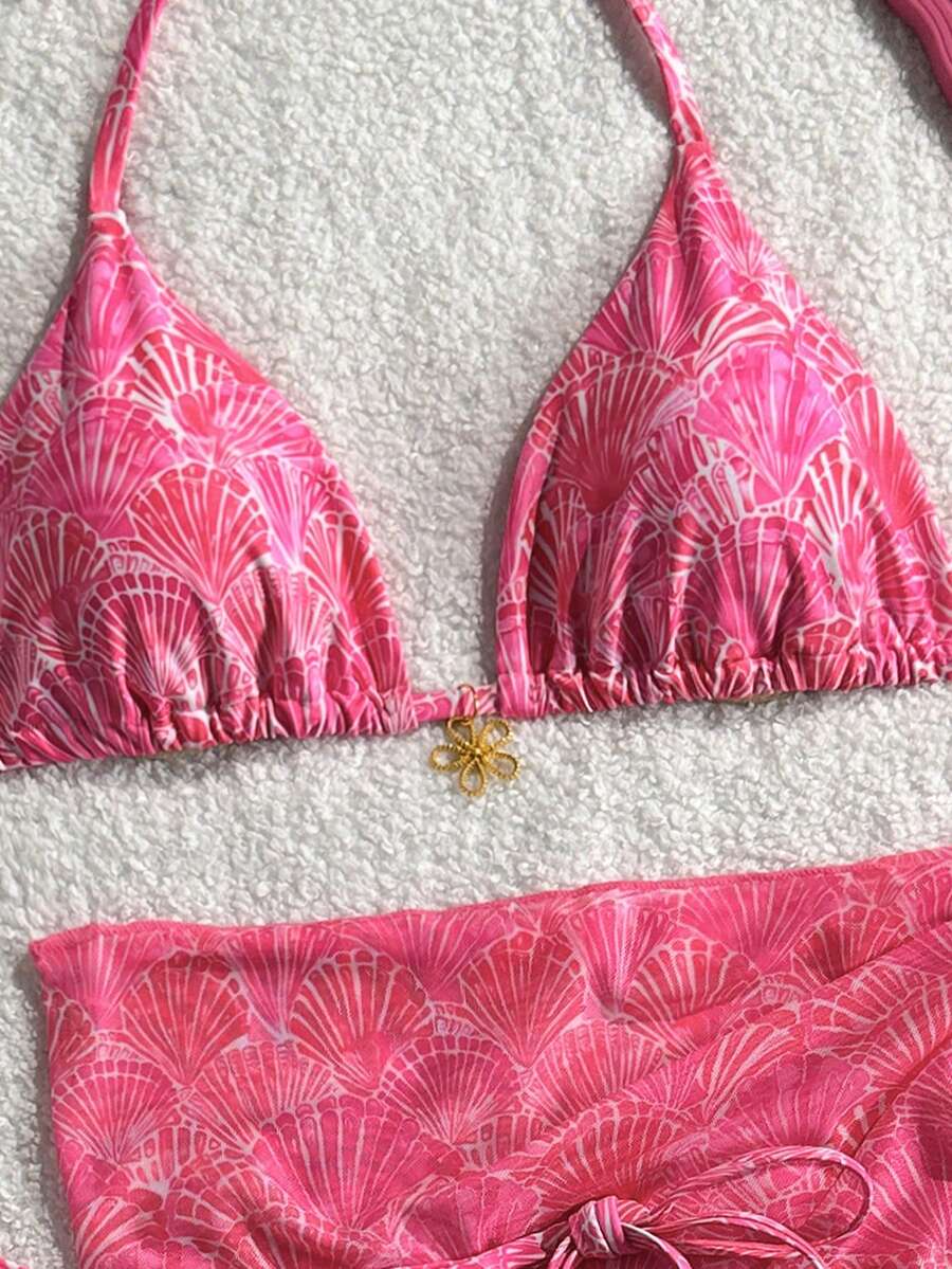 Women's 3-piece blue tropical shell print bikini set featuring a halter bralette top, low-waist tie-side bottom, and a matching sheer mesh cover-up skirt.