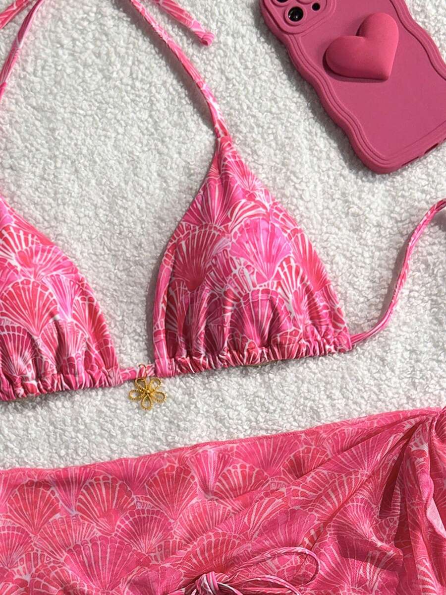 Women's 3-piece blue tropical shell print bikini set featuring a halter bralette top, low-waist tie-side bottom, and a matching sheer mesh cover-up skirt.