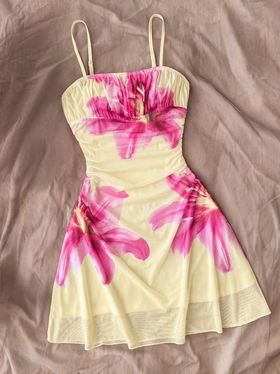 Tween girl yellow mini sundress with large pink floral hibiscus print, spaghetti straps, high waist, flared hem, and sleeveless cami style for summer beach wear