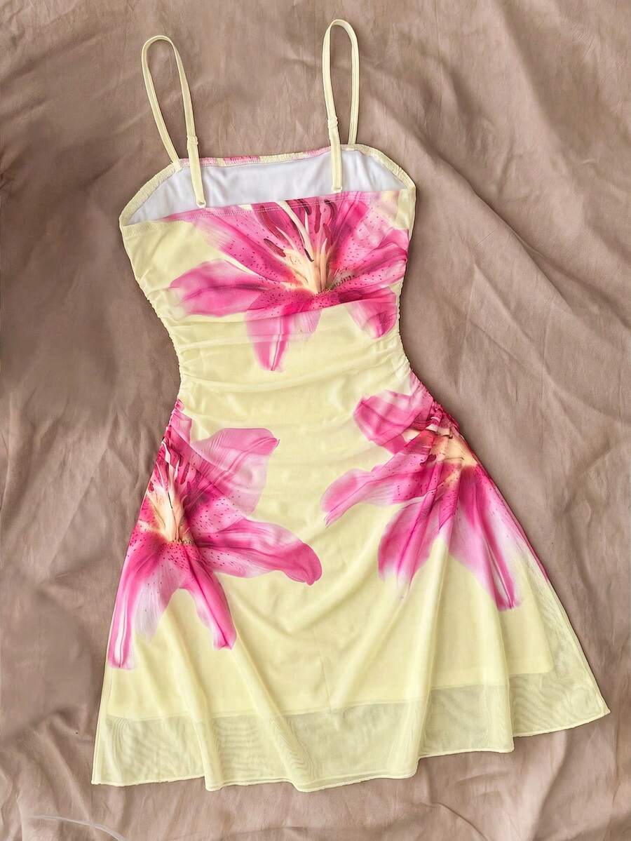Tween girl yellow mini sundress with large pink floral hibiscus print, spaghetti straps, high waist, flared hem, and sleeveless cami style for summer beach wear