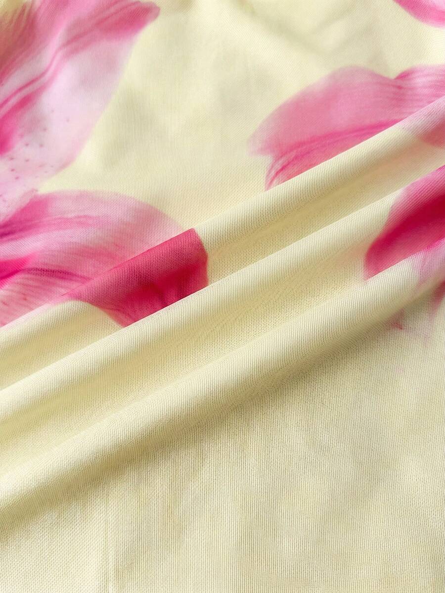 Tween girl yellow mini sundress with large pink floral hibiscus print, spaghetti straps, high waist, flared hem, and sleeveless cami style for summer beach wear