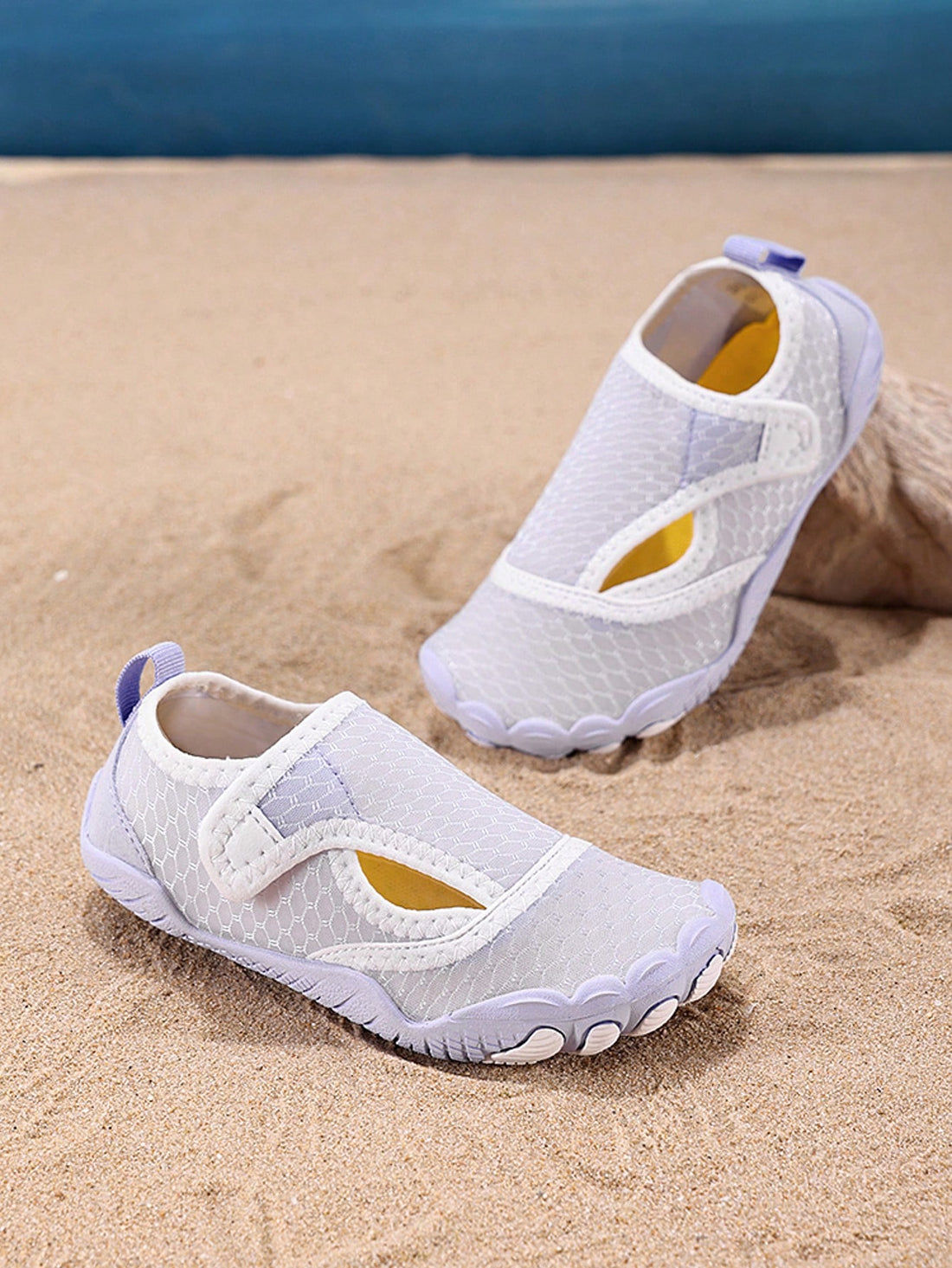 Mauve purple girls water shoes featuring a fabric upper, cut-out colorblock pattern, hook and loop strap, and non-slip rubber sole for outdoor wading.