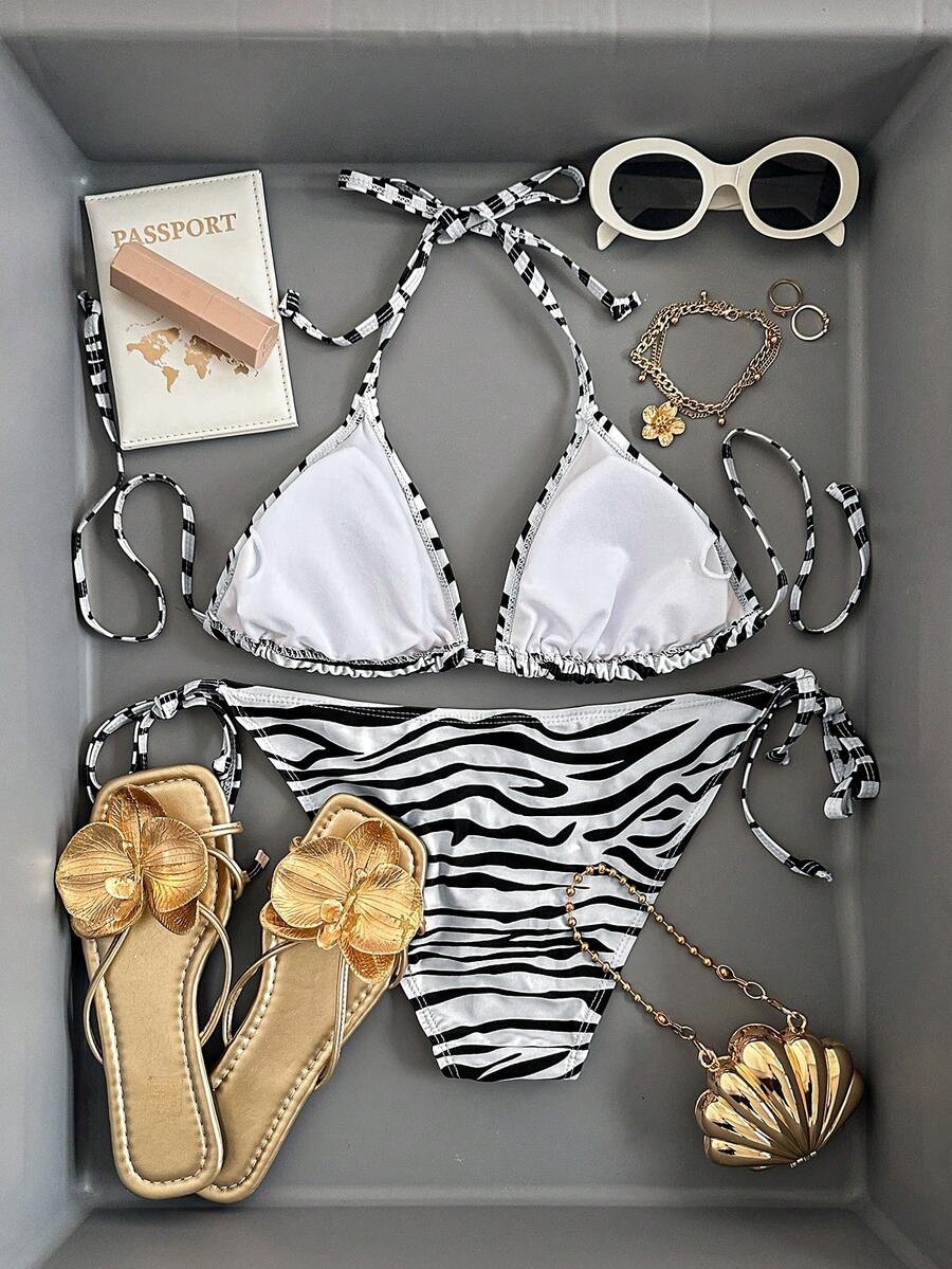 Women's black and white zebra print two-piece bikini set featuring a high waist tie-side bottom and a backless halter top with removable padding.