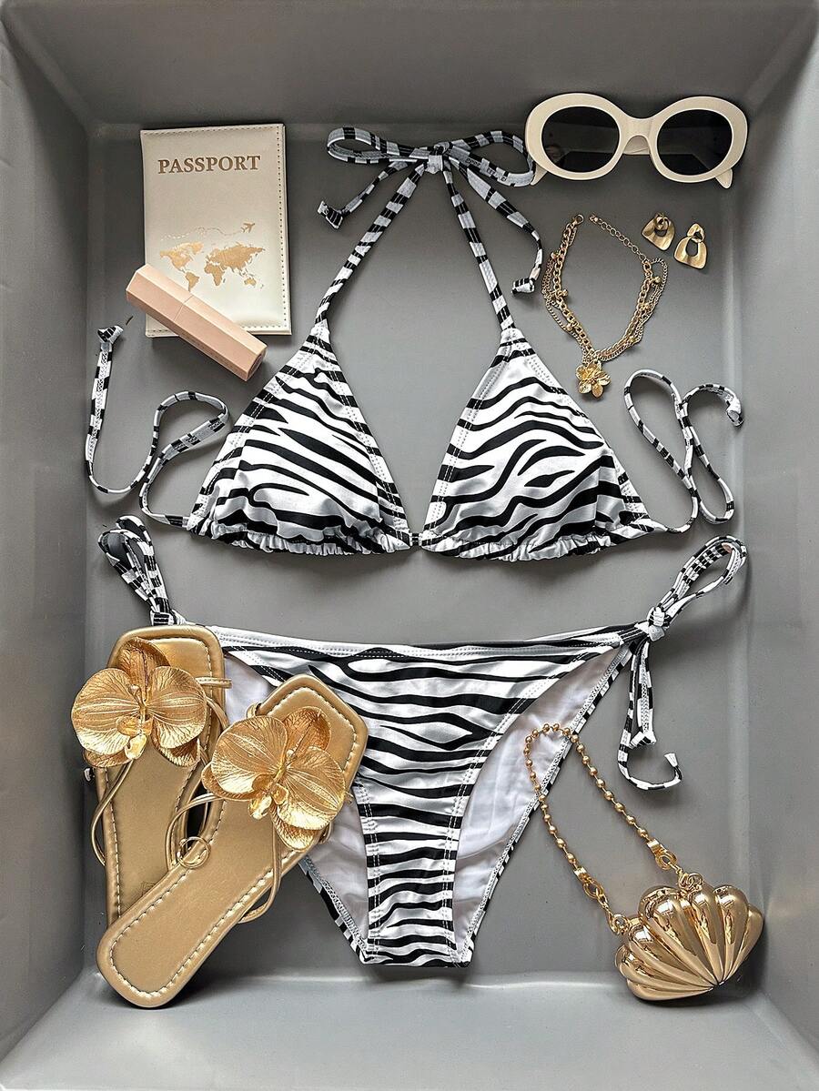 Women's black and white zebra print two-piece bikini set featuring a high waist tie-side bottom and a backless halter top with removable padding.