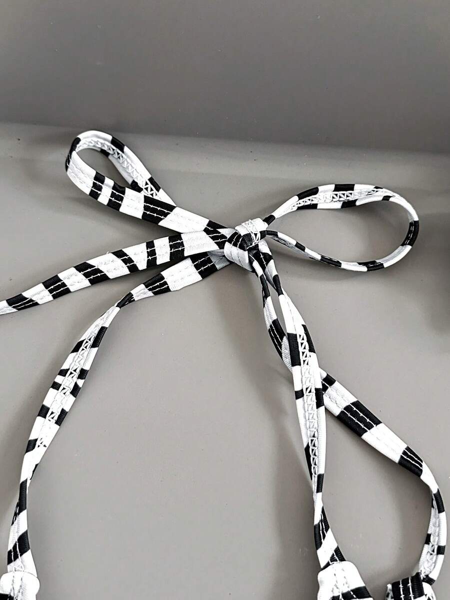 Women's black and white zebra print two-piece bikini set featuring a high waist tie-side bottom and a backless halter top with removable padding.