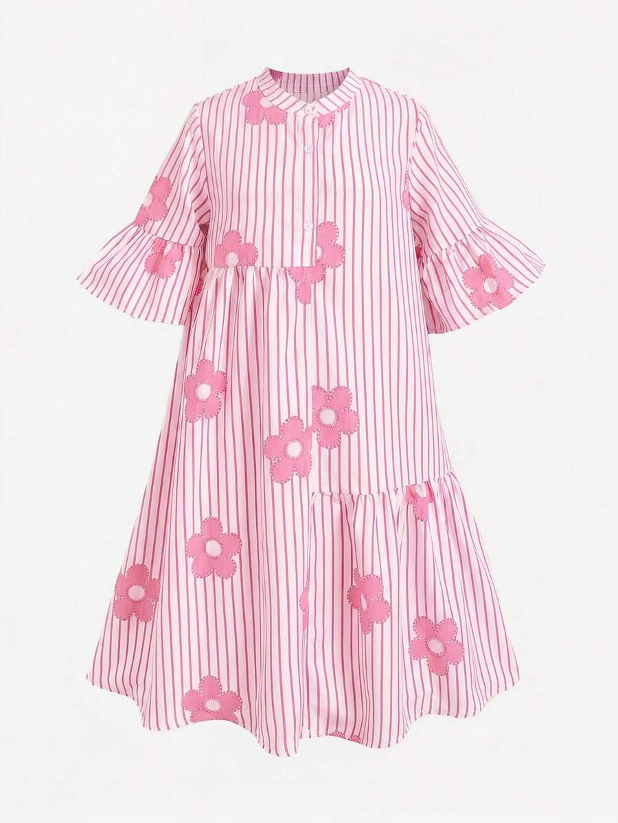 Tween girl wearing a black striped smock shirt dress with flounce half sleeves, a stand collar, and a ruffled hem.