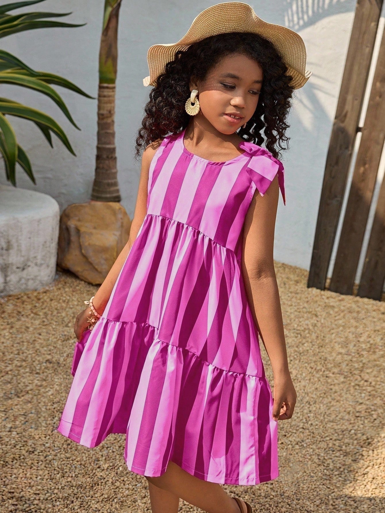 Tween girls blue striped sleeveless smock dress featuring a round neckline, high waist, and flounce ruffle hem.