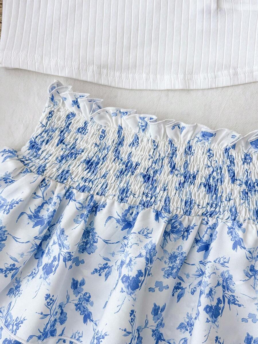 Tween girls blue and white 2-piece set with a striped halter neck vest top and a floral high-waist tiered paperbag skirt.
