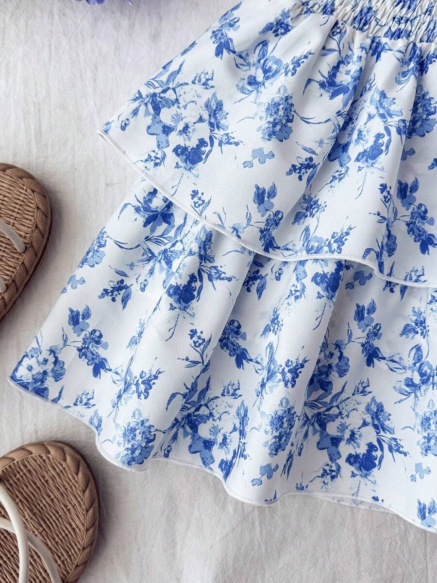 Tween girls blue and white 2-piece set with a striped halter neck vest top and a floral high-waist tiered paperbag skirt.