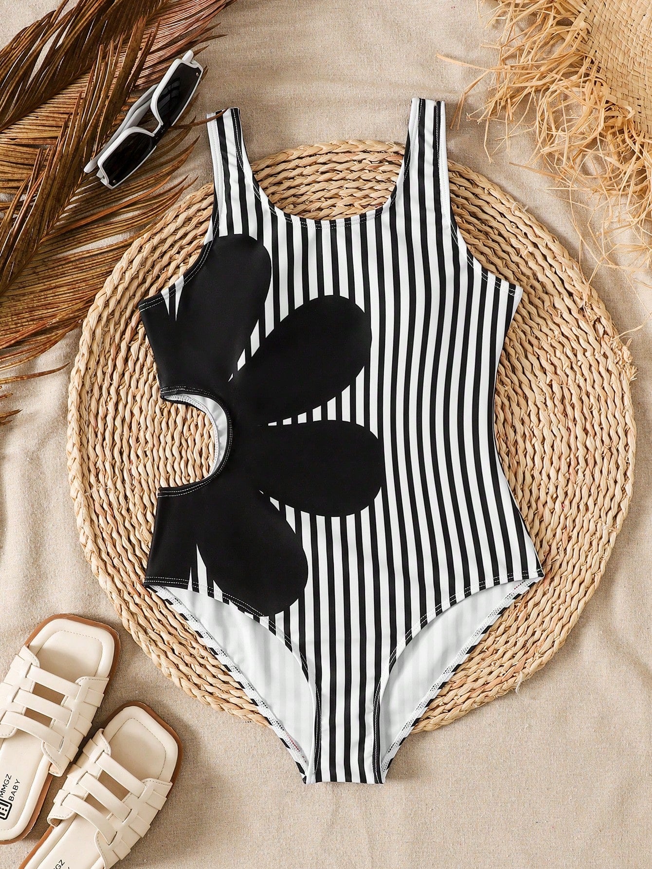 Tween girls' black and white one-piece swimsuit with striped patchwork design, scoop neck, asymmetrical cut-out detail, and fitted vacation swimwear style.