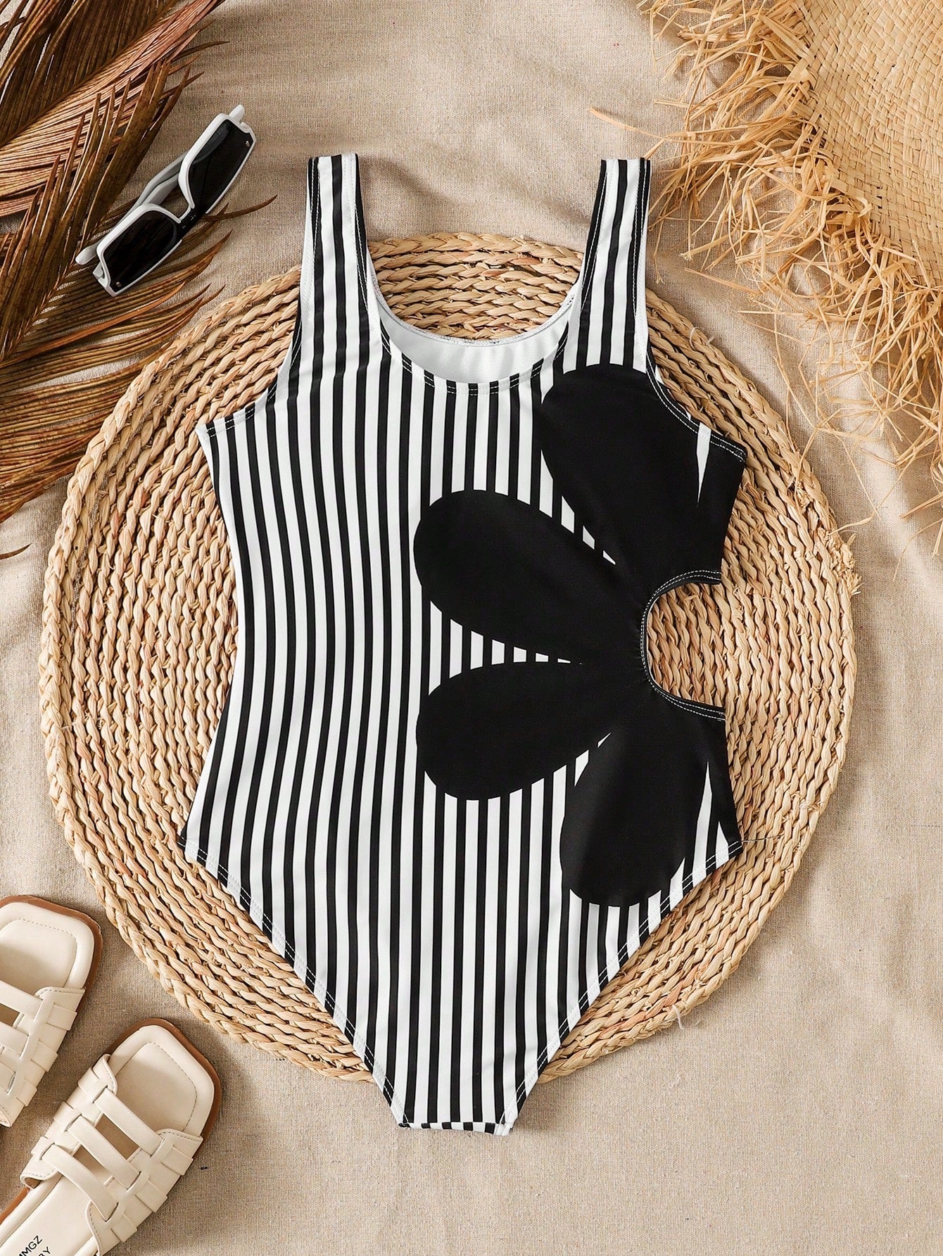 Tween girls' black and white one-piece swimsuit with striped patchwork design, scoop neck, asymmetrical cut-out detail, and fitted vacation swimwear style.